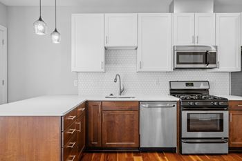 A kitchen with a white countertop and wooden cabinets.